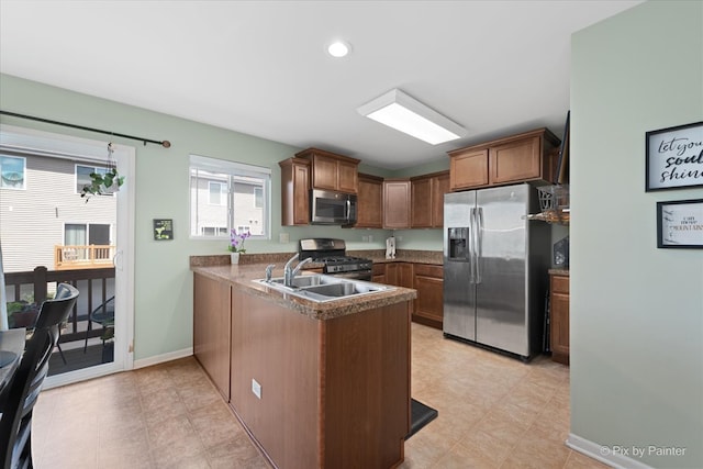 kitchen featuring kitchen peninsula, light tile patterned flooring, stainless steel appliances, and sink