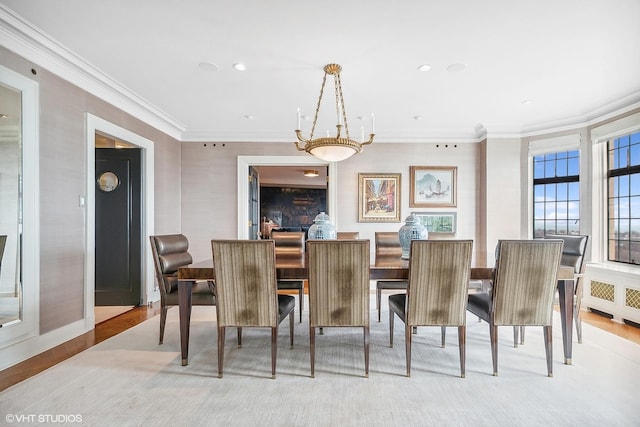 dining area with crown molding, radiator heating unit, and light wood-type flooring