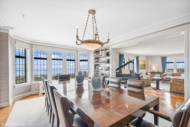 dining area with built in features, ornamental molding, and light hardwood / wood-style floors