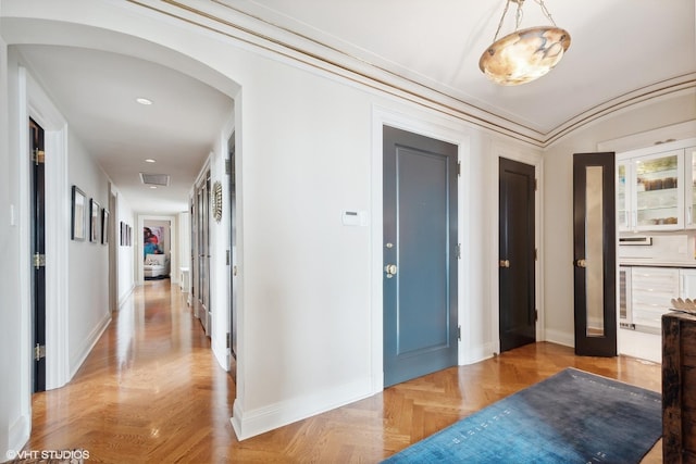 hall with light parquet flooring and ornamental molding