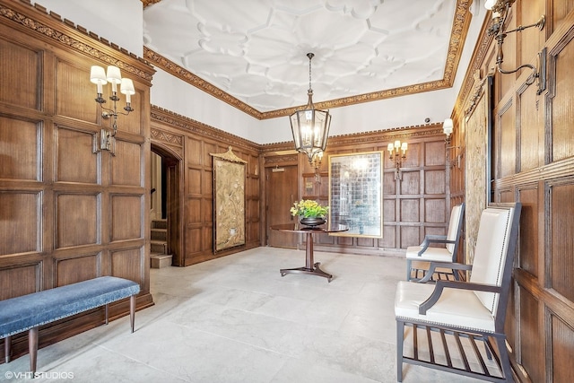 living area with crown molding, an inviting chandelier, and wood walls