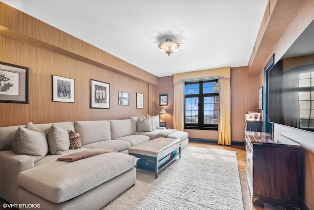 living room featuring wooden walls and light hardwood / wood-style floors