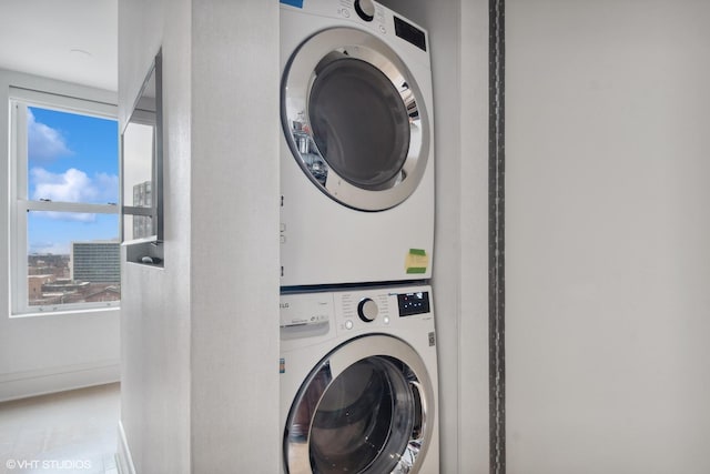 clothes washing area with stacked washing maching and dryer