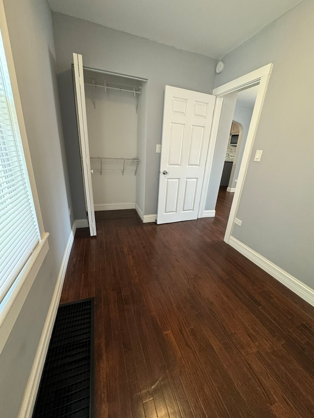 unfurnished bedroom featuring dark hardwood / wood-style flooring and a closet