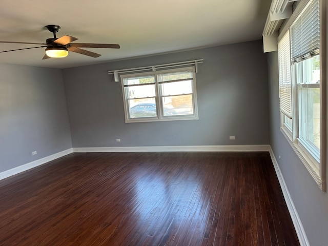 spare room featuring dark wood-type flooring and ceiling fan