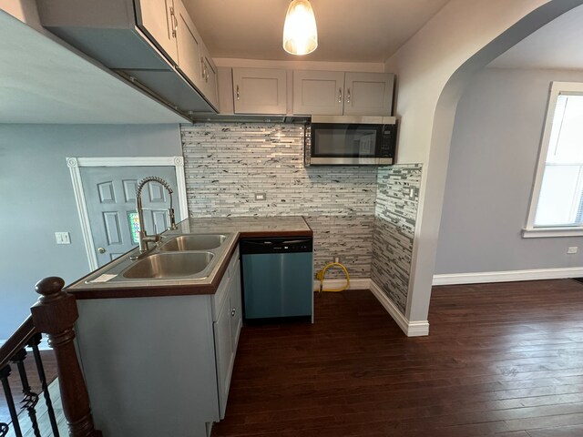 kitchen featuring appliances with stainless steel finishes, dark hardwood / wood-style floors, plenty of natural light, and gray cabinets