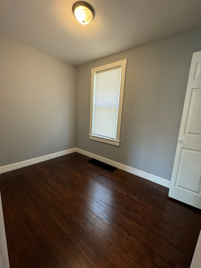 empty room with dark hardwood / wood-style flooring