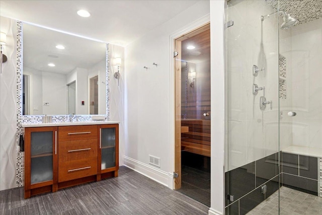 bathroom featuring hardwood / wood-style flooring, vanity, and a shower with shower door