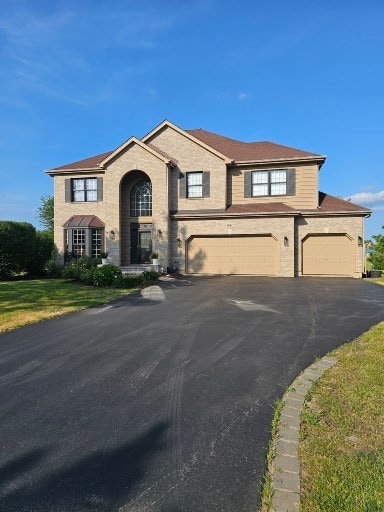 view of front of house featuring a garage and a front lawn