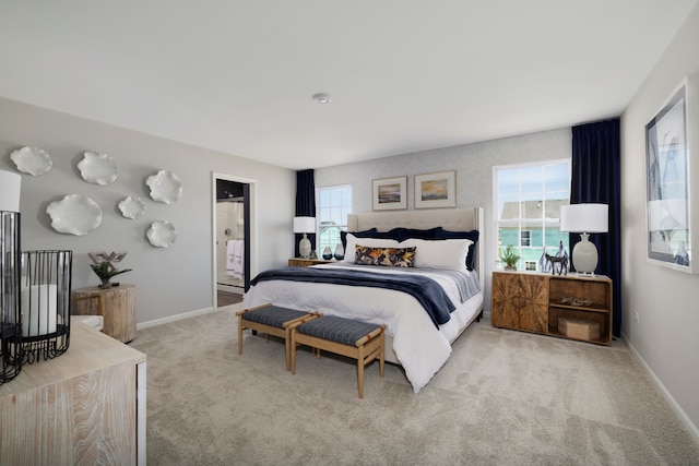 bedroom featuring ensuite bathroom and light carpet