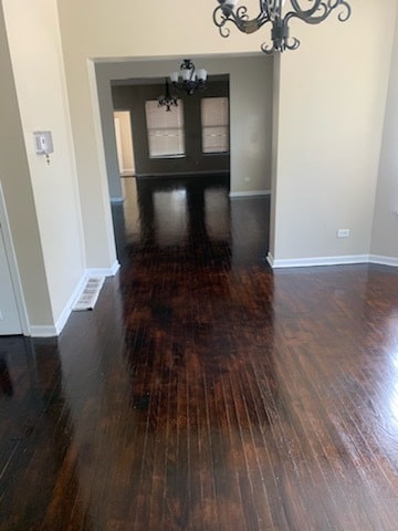 interior space featuring dark hardwood / wood-style floors and an inviting chandelier