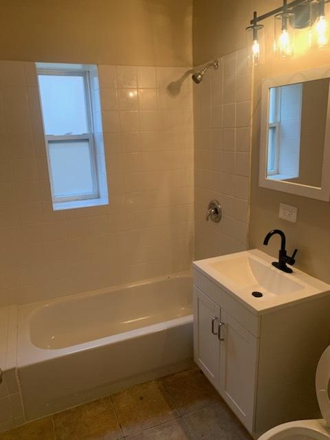 full bathroom with toilet, vanity, tile patterned floors, and tiled shower / bath