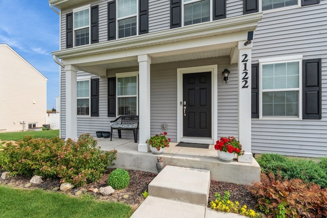 view of exterior entry featuring covered porch