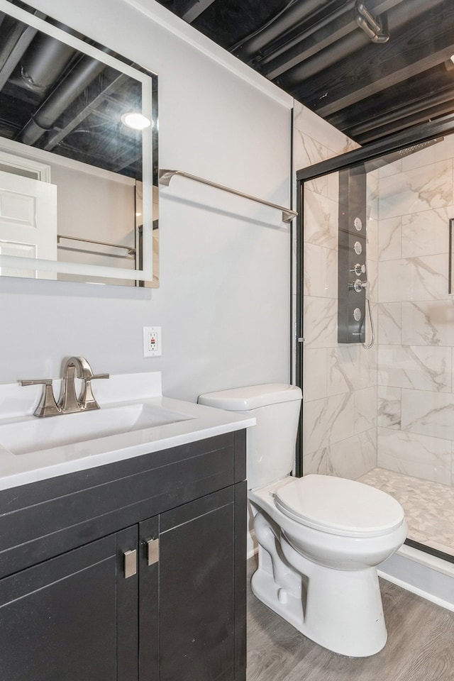 bathroom featuring vanity, toilet, hardwood / wood-style floors, and a shower with shower door