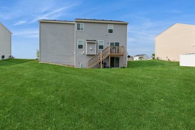 rear view of house featuring a lawn and a wooden deck