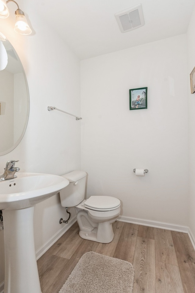 bathroom with toilet, hardwood / wood-style flooring, and sink