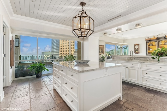 kitchen with a wealth of natural light, a kitchen island, and decorative light fixtures