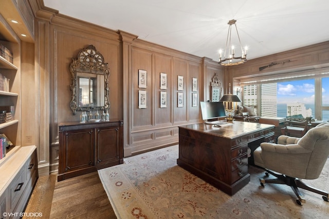 home office featuring dark wood-type flooring and a notable chandelier