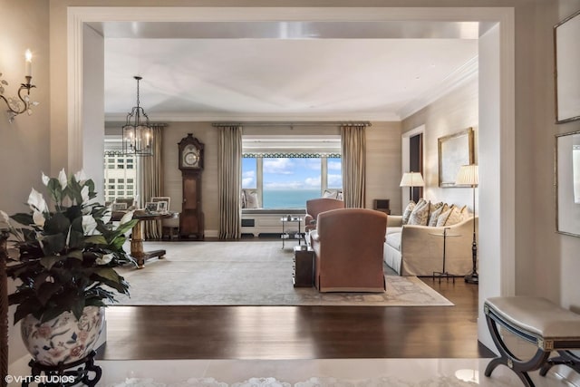 living room with hardwood / wood-style flooring, ornamental molding, and a chandelier