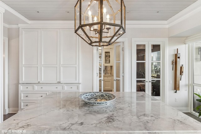 unfurnished dining area with an inviting chandelier, wood ceiling, crown molding, and french doors