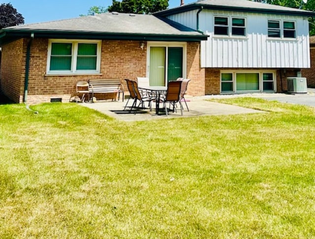 rear view of property featuring central AC unit, a yard, and a patio area