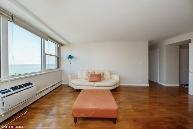 living room featuring a water view, hardwood / wood-style floors, and a baseboard heating unit