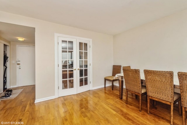 dining area with baseboards, wood finished floors, and french doors