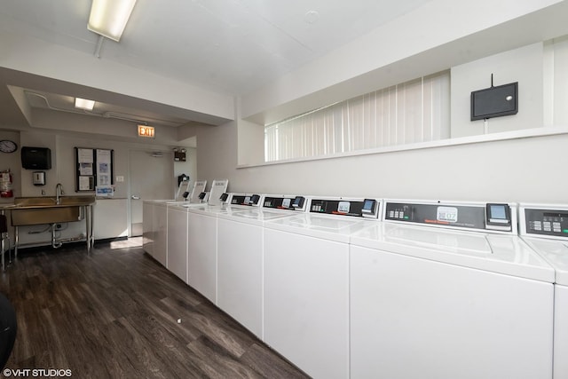 community laundry room featuring dark wood finished floors, a sink, and washing machine and clothes dryer