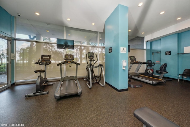 workout area featuring recessed lighting, a healthy amount of sunlight, and baseboards