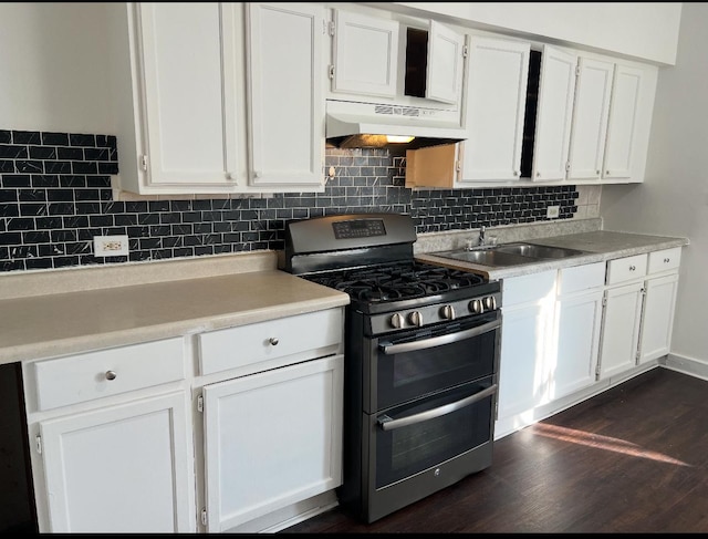 kitchen with under cabinet range hood, a sink, white cabinets, and range with two ovens