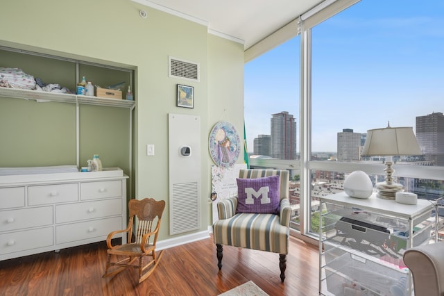 living area featuring expansive windows, hardwood / wood-style flooring, and a healthy amount of sunlight