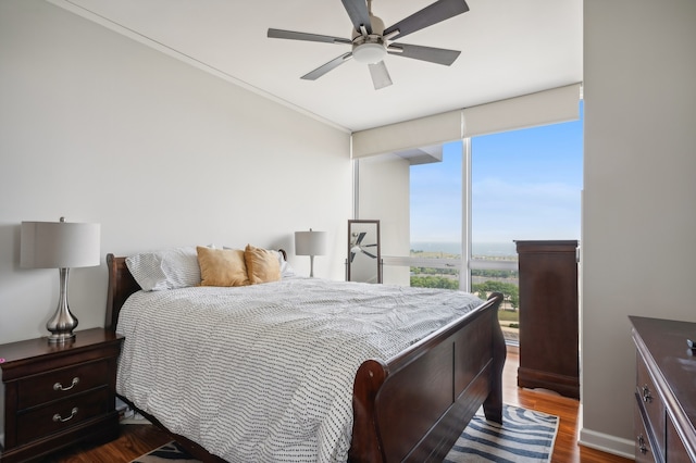 bedroom with ceiling fan, dark hardwood / wood-style floors, and ornamental molding