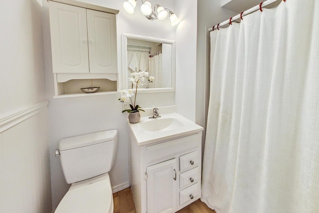 bathroom with hardwood / wood-style flooring, vanity, and toilet