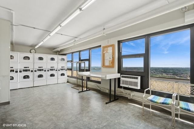 interior space with an AC wall unit and stacked washing maching and dryer