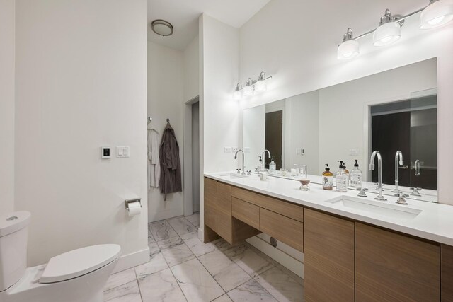 bathroom with a towering ceiling, vanity, and toilet