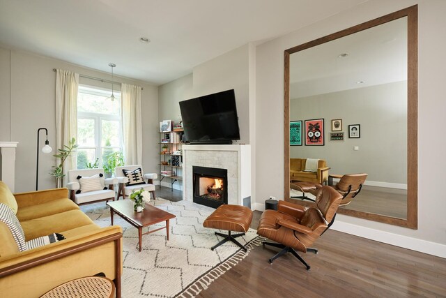 living room with a tile fireplace and light wood-type flooring