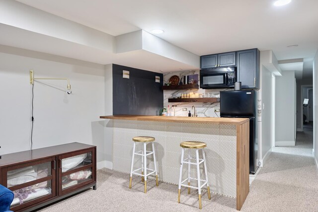 kitchen with light carpet, sink, fridge, kitchen peninsula, and a breakfast bar area