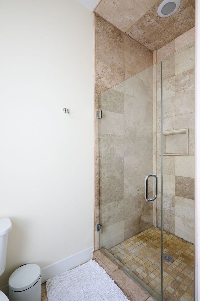 bathroom with toilet and an enclosed shower