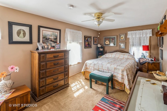 bedroom featuring light carpet, multiple windows, and ceiling fan