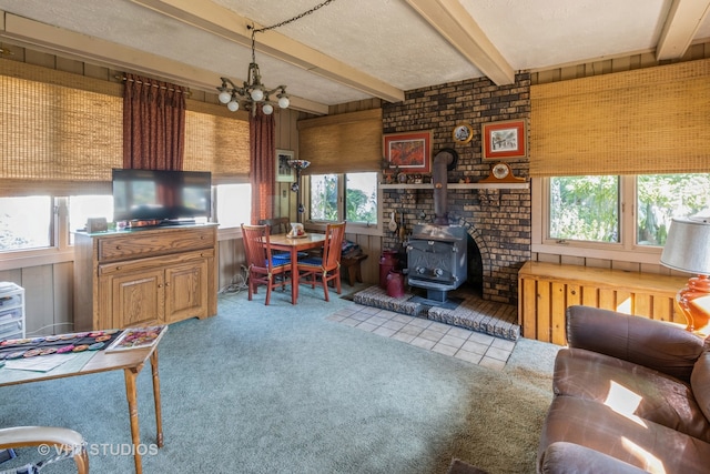 living room featuring light carpet, a wood stove, and plenty of natural light