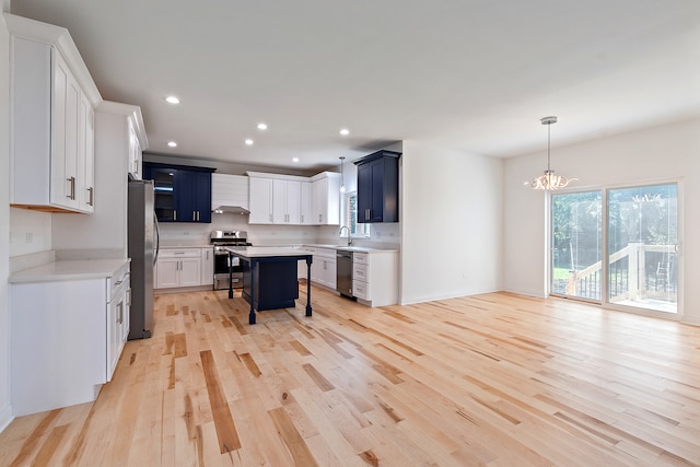 kitchen featuring light wood-type flooring, stainless steel appliances, an inviting chandelier, and a breakfast bar