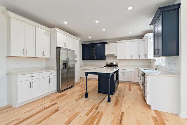 kitchen with a center island, light hardwood / wood-style flooring, stainless steel appliances, sink, and a breakfast bar area