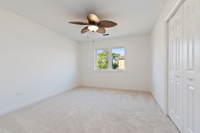 unfurnished bedroom featuring a closet, ceiling fan, and light carpet