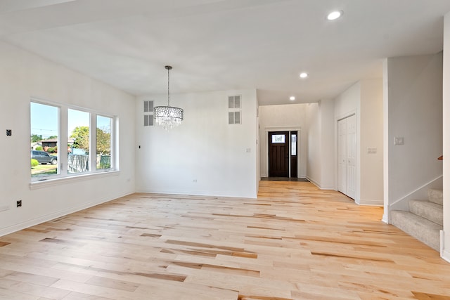 interior space with light wood-type flooring and a chandelier