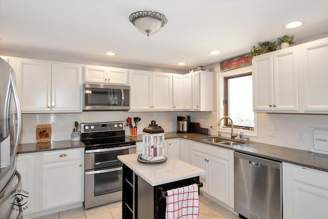 kitchen featuring white cabinets, appliances with stainless steel finishes, and dark stone counters