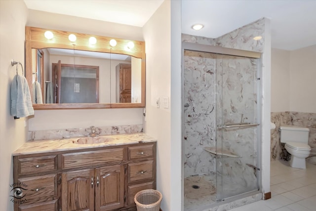 bathroom featuring tile patterned flooring, vanity, toilet, and a shower with door