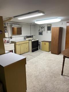 kitchen with light carpet and black / electric stove