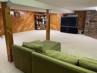 carpeted living room featuring wooden walls