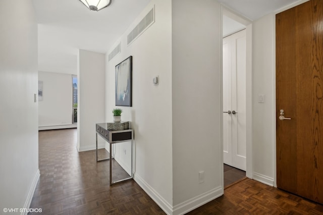 corridor with baseboard heating and dark parquet flooring