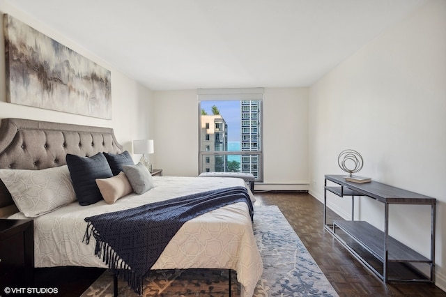 bedroom featuring a baseboard heating unit and dark parquet flooring